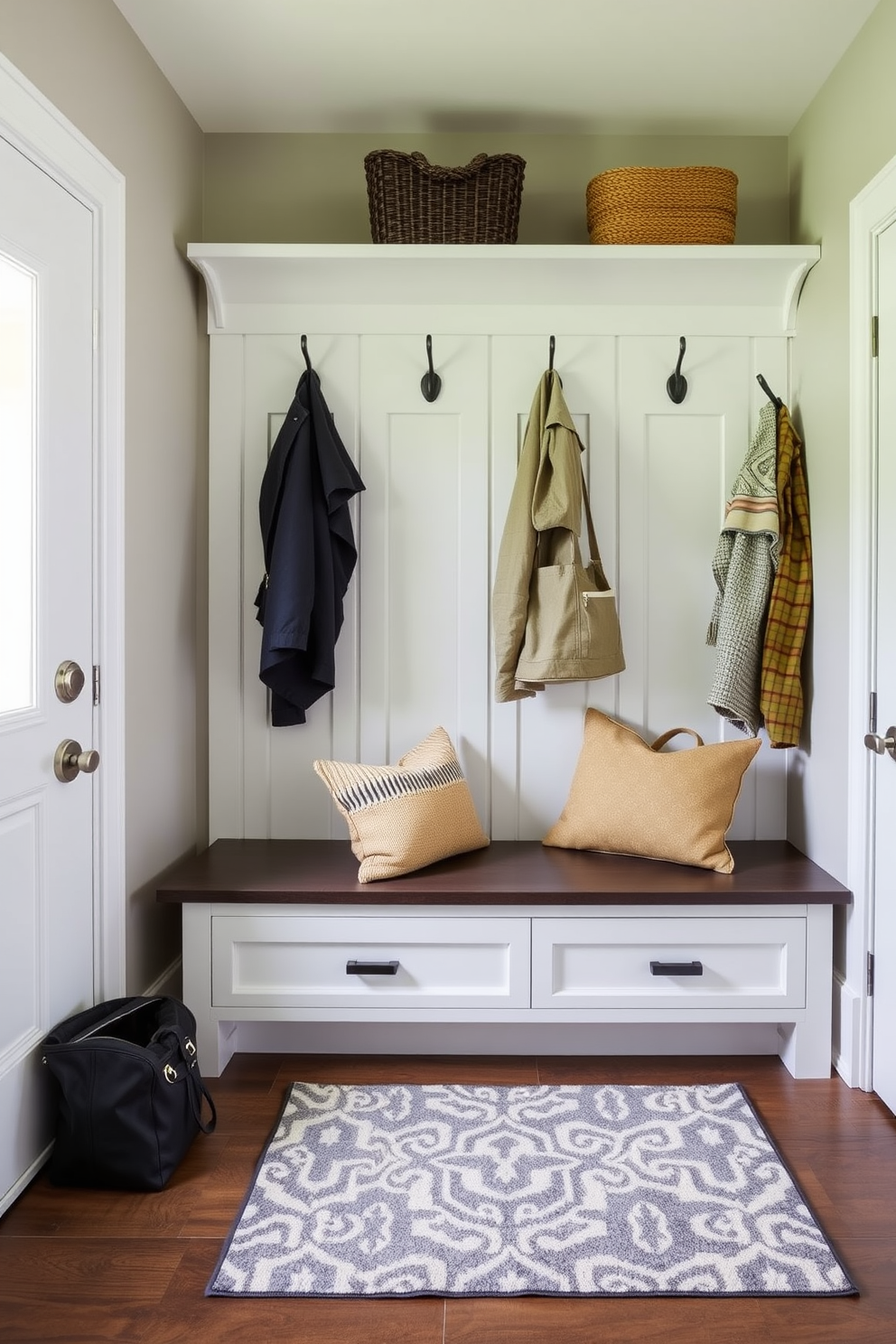 A modern mudroom features wall-mounted hooks for easy access to coats and bags. The space includes a built-in bench with storage underneath, complemented by a stylish area rug.