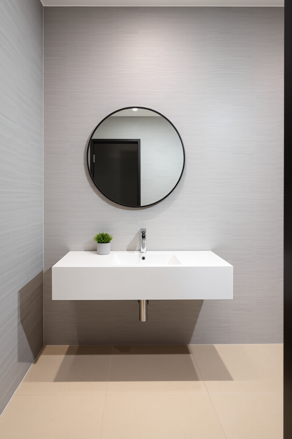 Sleek floating vanity with an integrated sink is the focal point of the modern powder room. The vanity is finished in a high-gloss white, complementing the minimalist aesthetic of the space. The walls are adorned with textured wallpaper in a soft gray tone, adding depth and sophistication. A large round mirror with a thin black frame hangs above the vanity, enhancing the contemporary feel. The floor features large format tiles in a light beige, creating a seamless look. Accents of greenery are introduced with a small potted plant placed on the vanity.