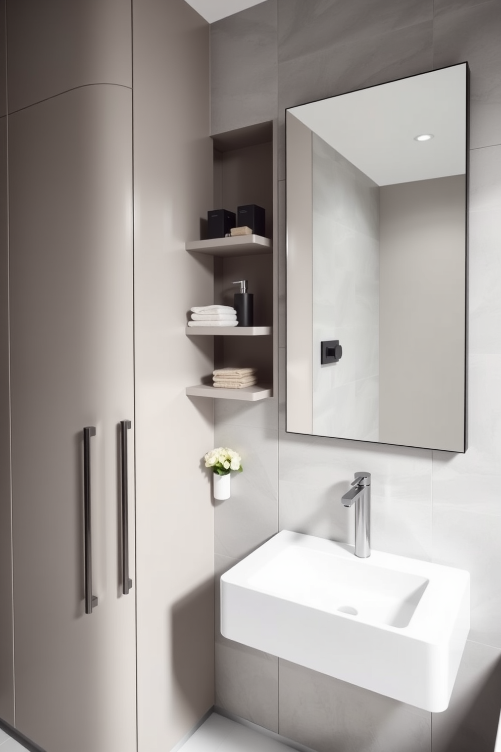 A modern powder room featuring sleek cabinetry with integrated storage solutions. The walls are adorned with light gray tiles, and a stylish wall-mounted sink saves floor space while providing functionality. Incorporate floating shelves above the sink for decorative items and essentials. A full-length mirror enhances the sense of space, reflecting the elegant fixtures and minimalist decor.