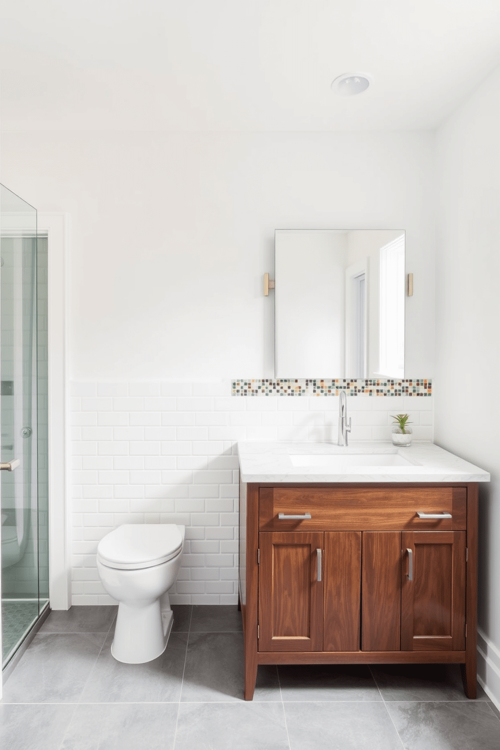 A modern bathroom featuring a subway tile backsplash adorned with a vibrant mosaic border. The walls are painted in a soft white, creating a bright and airy atmosphere, while the floor is covered in large gray tiles for a sleek contrast. The mosaic tiles add a pop of color and texture, drawing attention to the area above the sink. A stylish wooden vanity with a polished countertop complements the design, enhancing the overall elegance of the space.