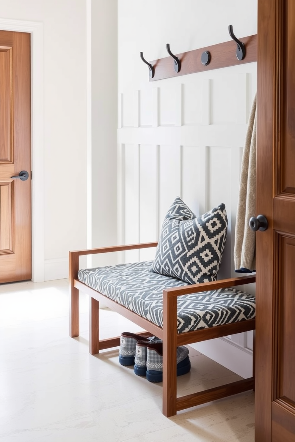 A contemporary mudroom features a stylish bench adorned with geometric patterns. The bench is upholstered in a soft fabric, complemented by a sleek wooden frame that adds warmth to the space.