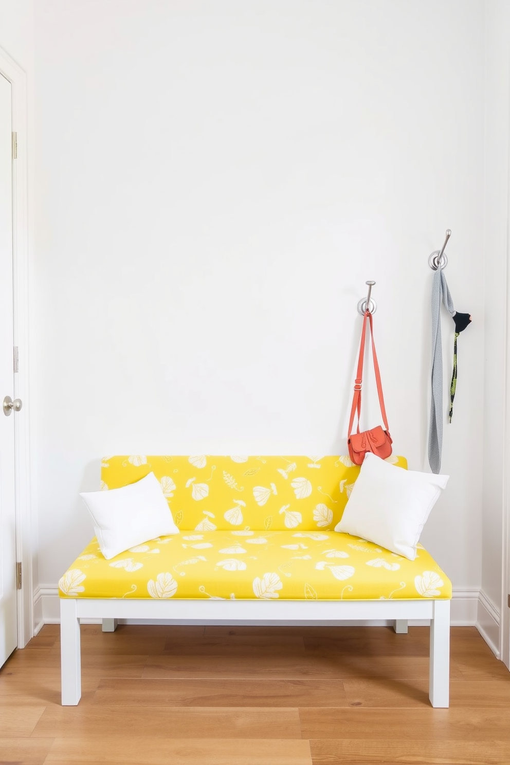 Brightly colored bench for a cheerful vibe. The bench is upholstered in a vibrant yellow fabric with playful patterns, creating an inviting atmosphere. Flanking the bench, there are hooks for hanging coats and bags, crafted from brushed nickel for a modern touch. The walls are painted in a soft white, enhancing the brightness of the space and making the bench the focal point.