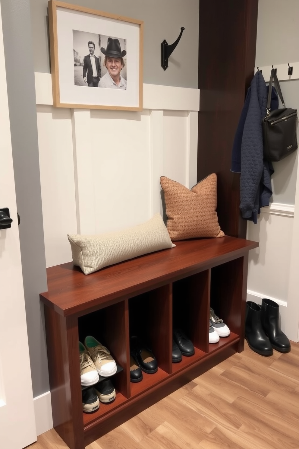 A functional built-in bench with storage is positioned against the wall in a stylish mudroom. The bench features a cushioned seat in a neutral fabric and underneath, there are multiple cubbies for shoes and outdoor gear.