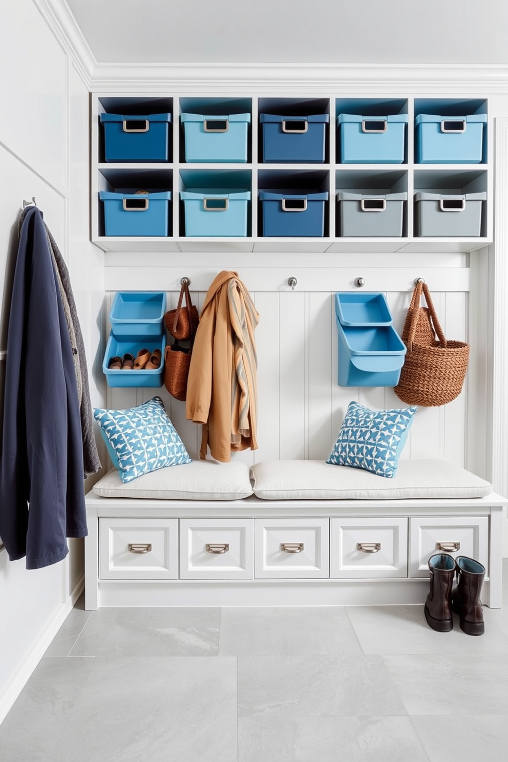 A stylish mudroom featuring color-coordinated storage bins arranged neatly along the wall. The bins are in varying shades of blue and gray, providing a cohesive look while offering ample storage for shoes and outdoor gear. The flooring is a durable tile in a light gray hue, complementing the overall color scheme. A bench with soft cushions sits below a row of hooks for coats, creating a welcoming and functional space.