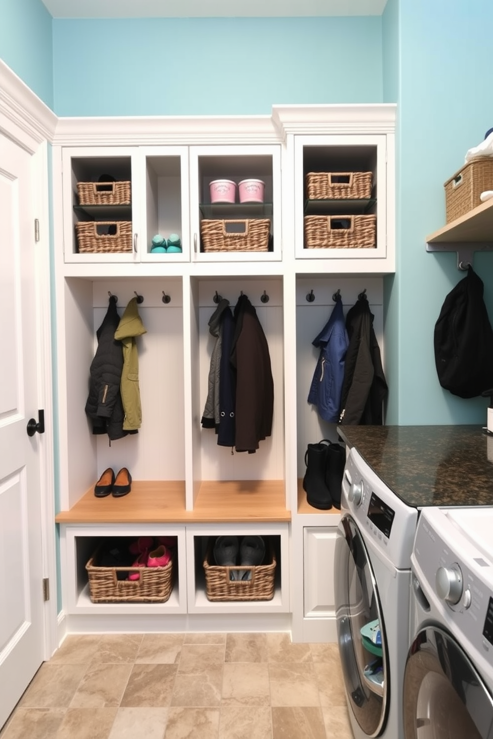 A functional mudroom featuring built-in cubbies for organized kids gear storage. Each cubby is equipped with hooks for coats and baskets for shoes, creating a tidy and inviting space. Adjacent to the cubbies, a stylish laundry area includes a washer and dryer with a countertop for folding clothes. The walls are painted a soft blue, and the floor is covered with durable, water-resistant tiles.