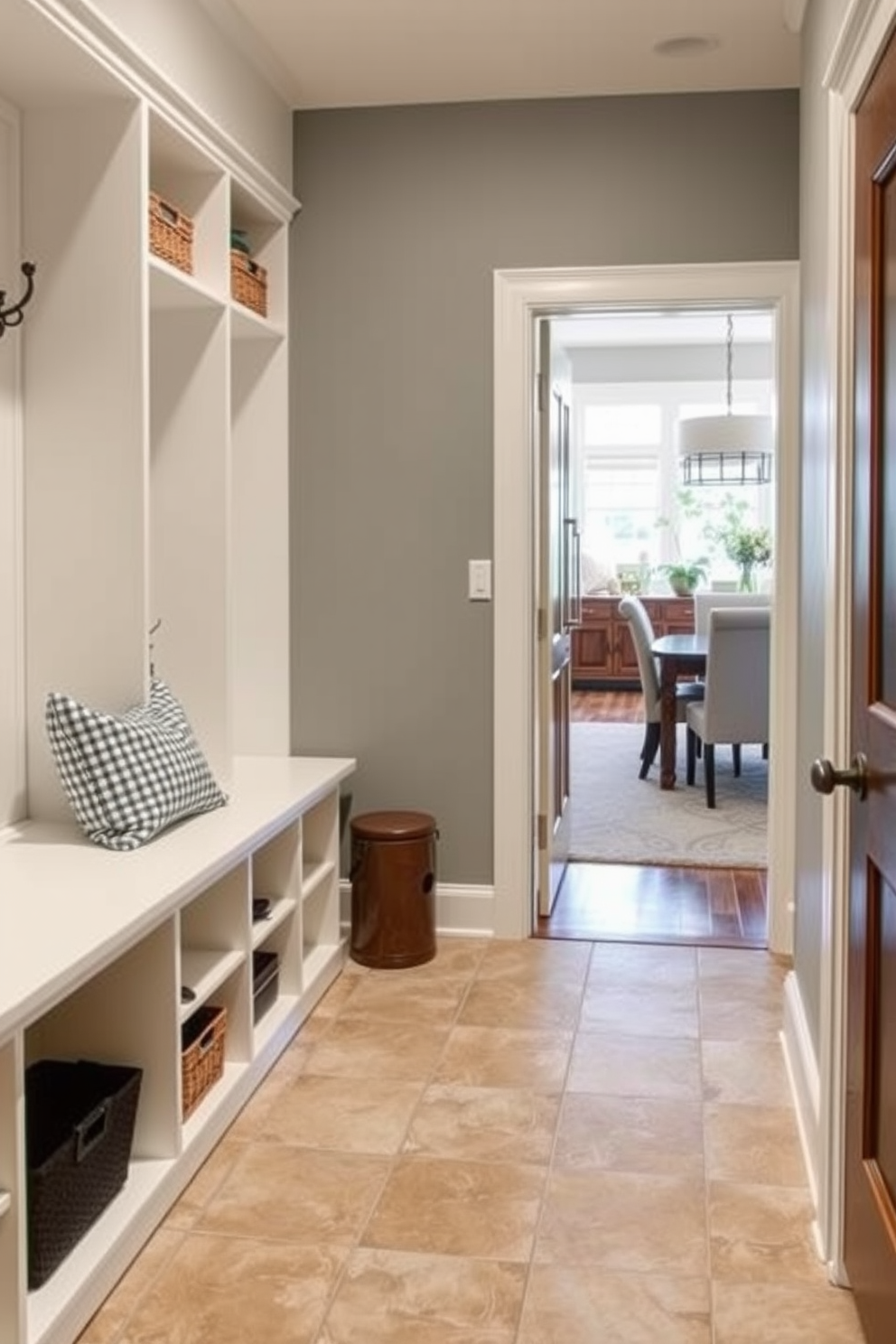 A functional mudroom design features durable tile flooring that ensures easy cleaning and maintenance. The space includes built-in storage solutions such as cubbies and hooks, seamlessly connecting to the dining room for convenience.