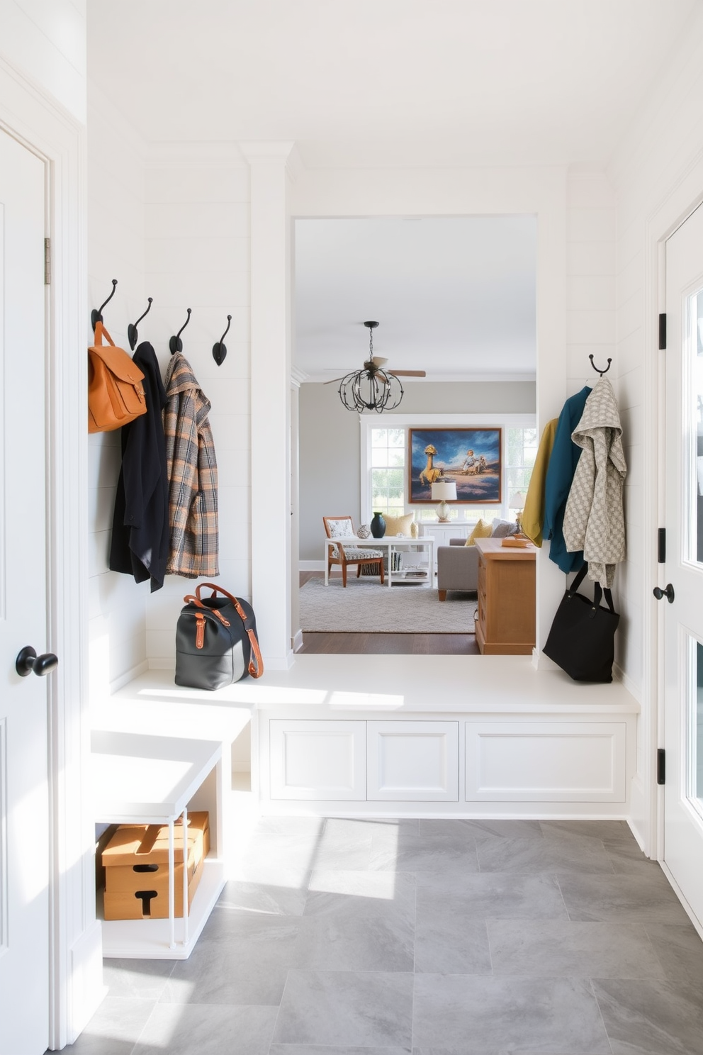 A mudroom designed for functionality and style features built-in benches with hidden storage compartments beneath. The walls are adorned with shiplap in a soft white hue, while the floor showcases durable gray tiles for easy maintenance. Adjacent to the family room, the mudroom includes hooks for coats and bags, ensuring a clutter-free environment. A large window allows natural light to flood the space, enhancing the inviting atmosphere.