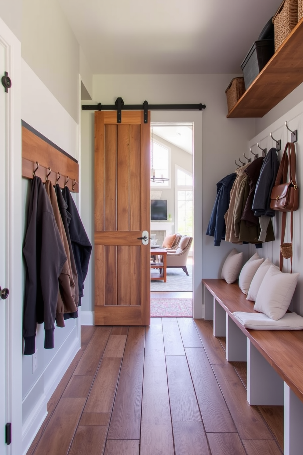 A cozy mudroom featuring a sliding barn door that opens to a spacious area. The walls are painted in a soft gray, and the floor is adorned with rustic wooden planks. Built-in benches with plush cushions line one side, providing a comfortable spot to sit. Hooks above the benches hold an array of jackets and bags, adding to the functional charm of the space. Adjacent to the family room, this mudroom seamlessly blends style and practicality. Large windows allow natural light to flood the area, enhancing the inviting atmosphere.