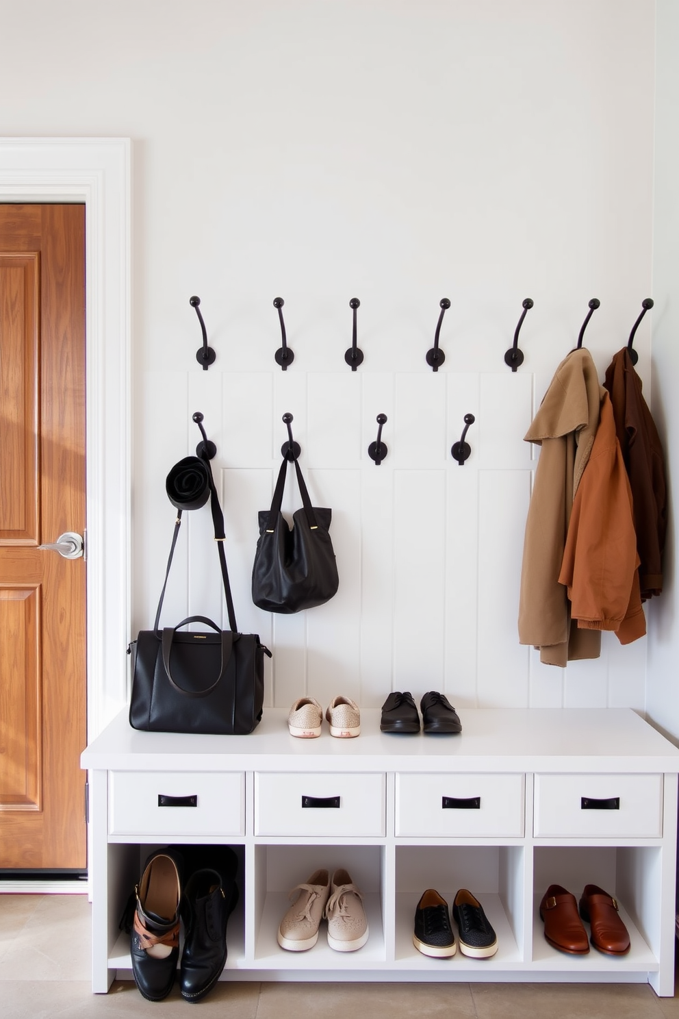 A functional mudroom design near the garage features a series of stylish wall hooks arranged at varying heights for easy access. Beneath the hooks, a built-in bench with storage compartments provides a convenient space for shoes and bags, enhancing the overall organization of the area.