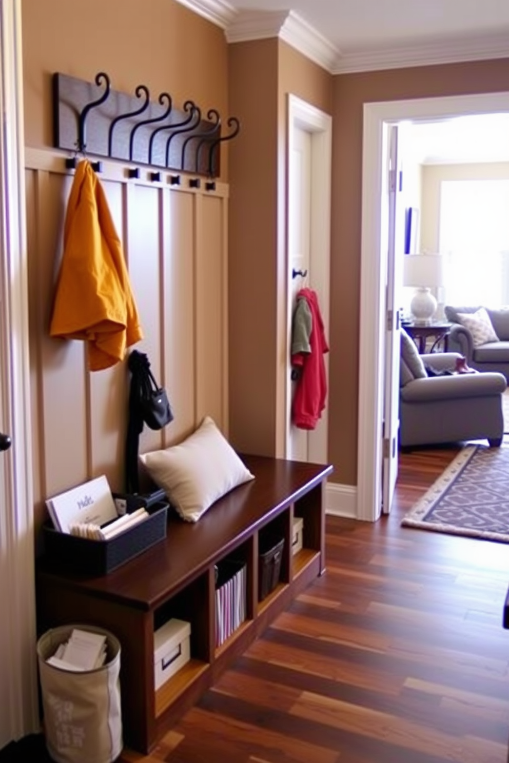 A functional drop zone for keys and mail is designed with a built-in bench and storage cubbies. The walls are painted in a warm neutral tone, and a stylish coat rack is mounted above the bench for easy access. The mudroom features durable flooring that can withstand heavy foot traffic, complemented by a patterned area rug for added warmth. Natural light floods the space through a nearby window, creating an inviting atmosphere that seamlessly connects to the living room.