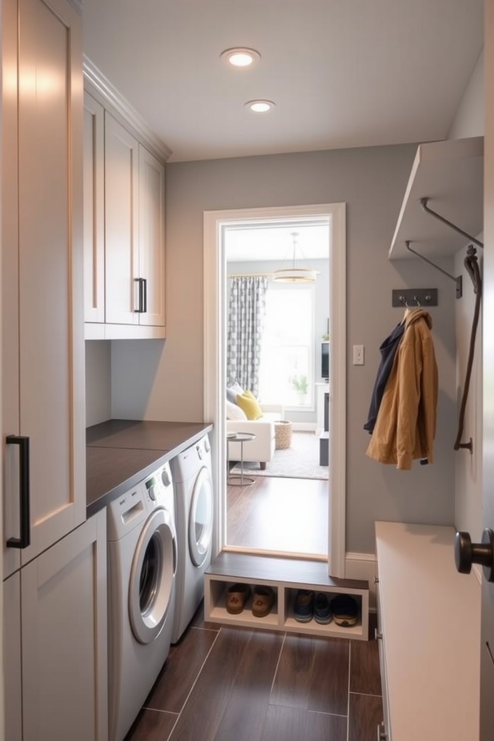 A functional mudroom laundry combo designed for efficiency. The space features built-in cabinetry with a sleek countertop for folding clothes and a washer dryer unit tucked away behind stylish doors. Adjacent to the living room, the mudroom is designed with easy access in mind. It includes a bench with storage underneath for shoes and hooks above for coats, all in a cohesive color palette that complements the living area.