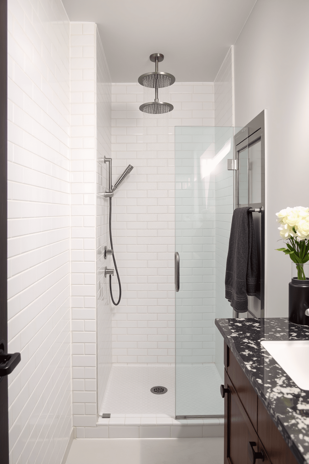 A narrow bathroom design featuring a luxurious rain shower head installed above a sleek glass shower enclosure. The walls are adorned with elegant white subway tiles, complemented by a stylish dark wood vanity with a polished granite countertop.