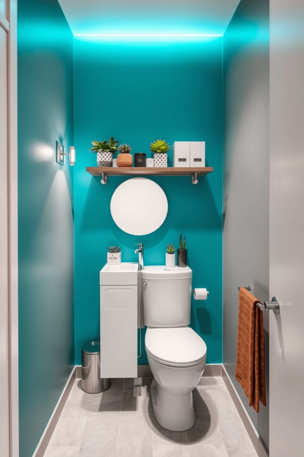 A narrow bathroom design featuring a vibrant accent wall painted in a bold teal color. The space includes a sleek white vanity with a round mirror above it, complemented by modern lighting fixtures on either side. To maximize space, a floating shelf is installed above the toilet, adorned with decorative plants and stylish storage boxes. The floor is covered with light gray tiles, creating a clean and contemporary look that enhances the overall design.