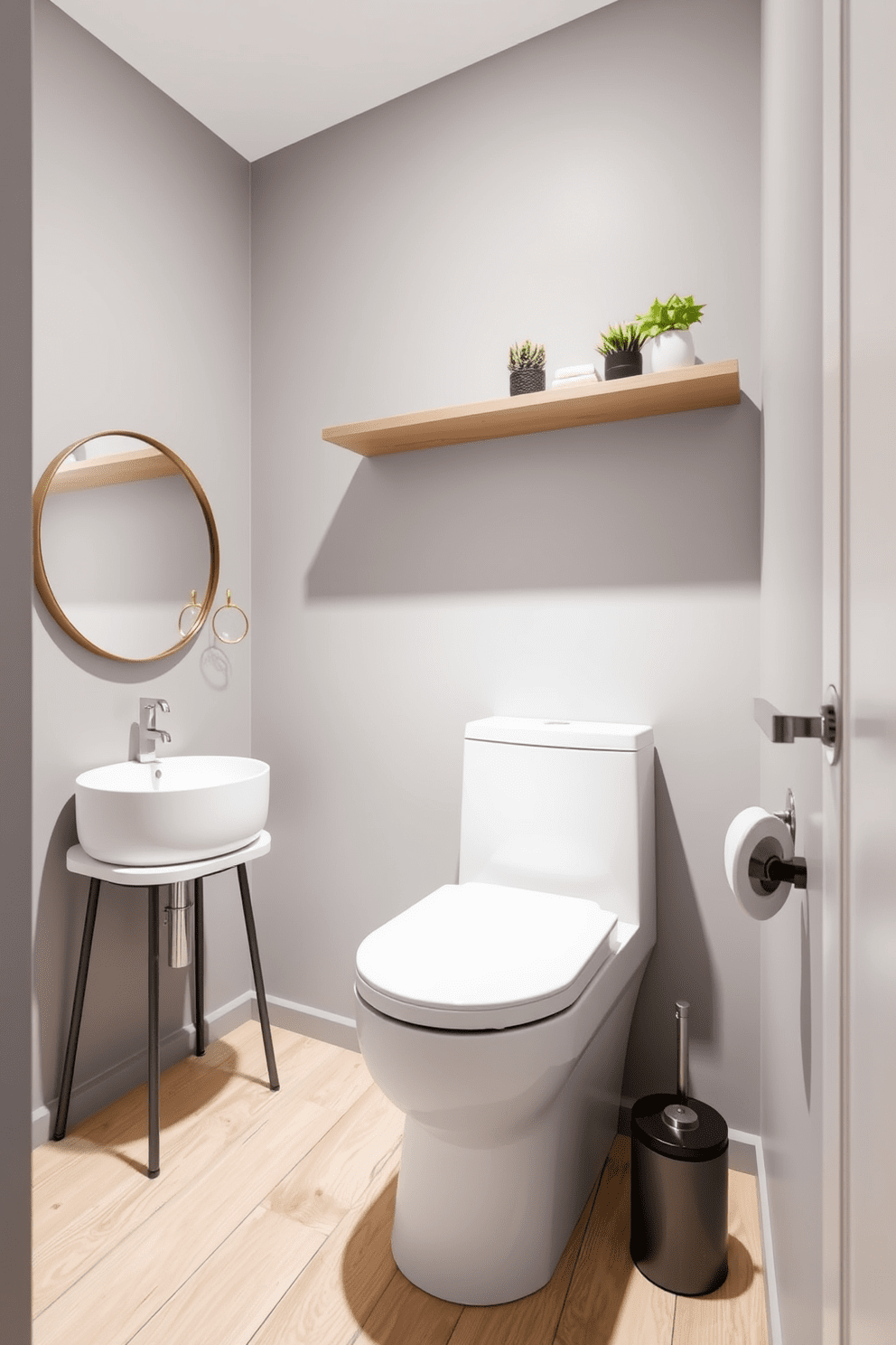 A narrow bathroom design featuring a sleek floating shelf above the toilet. The walls are painted in a soft gray tone, and the floor is adorned with light wood planks for a warm touch. To the left of the toilet, a compact vanity with a round mirror provides functional elegance. Accents of greenery are introduced with small potted plants placed on the floating shelf, adding a refreshing vibe.