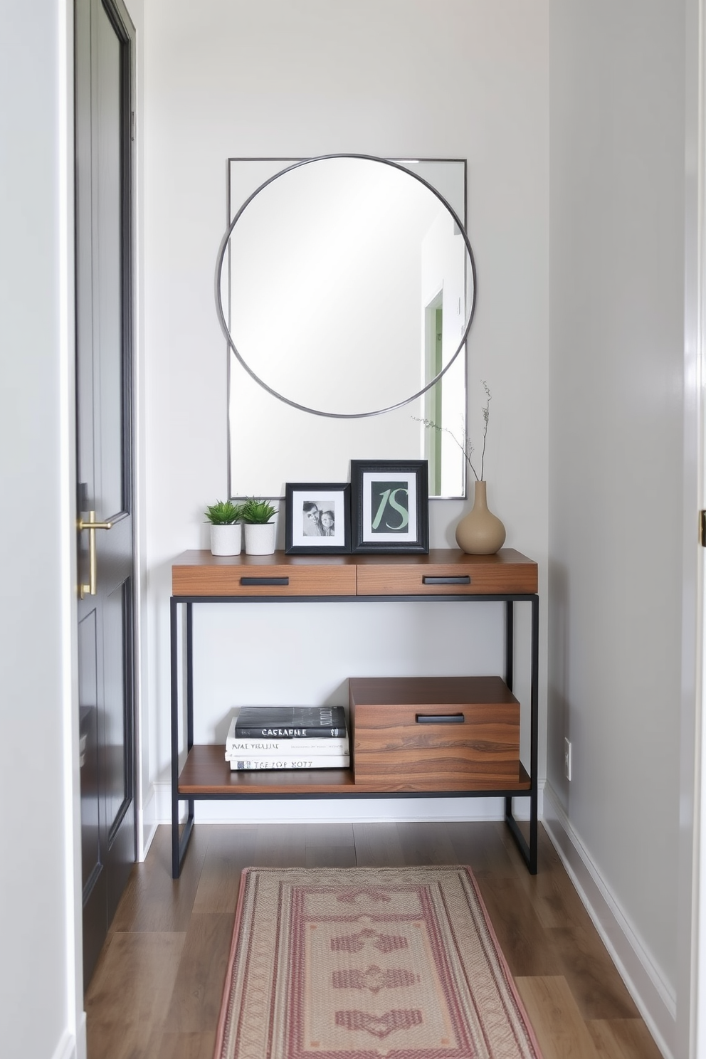 A stylish console table with storage options is positioned against the wall in a narrow entryway. The table features a sleek design with a combination of wood and metal, complemented by decorative items like a small plant and a framed photo. Above the console table, a large mirror enhances the sense of space and light. The walls are painted in a soft neutral tone, and a runner rug adds warmth and texture to the floor.