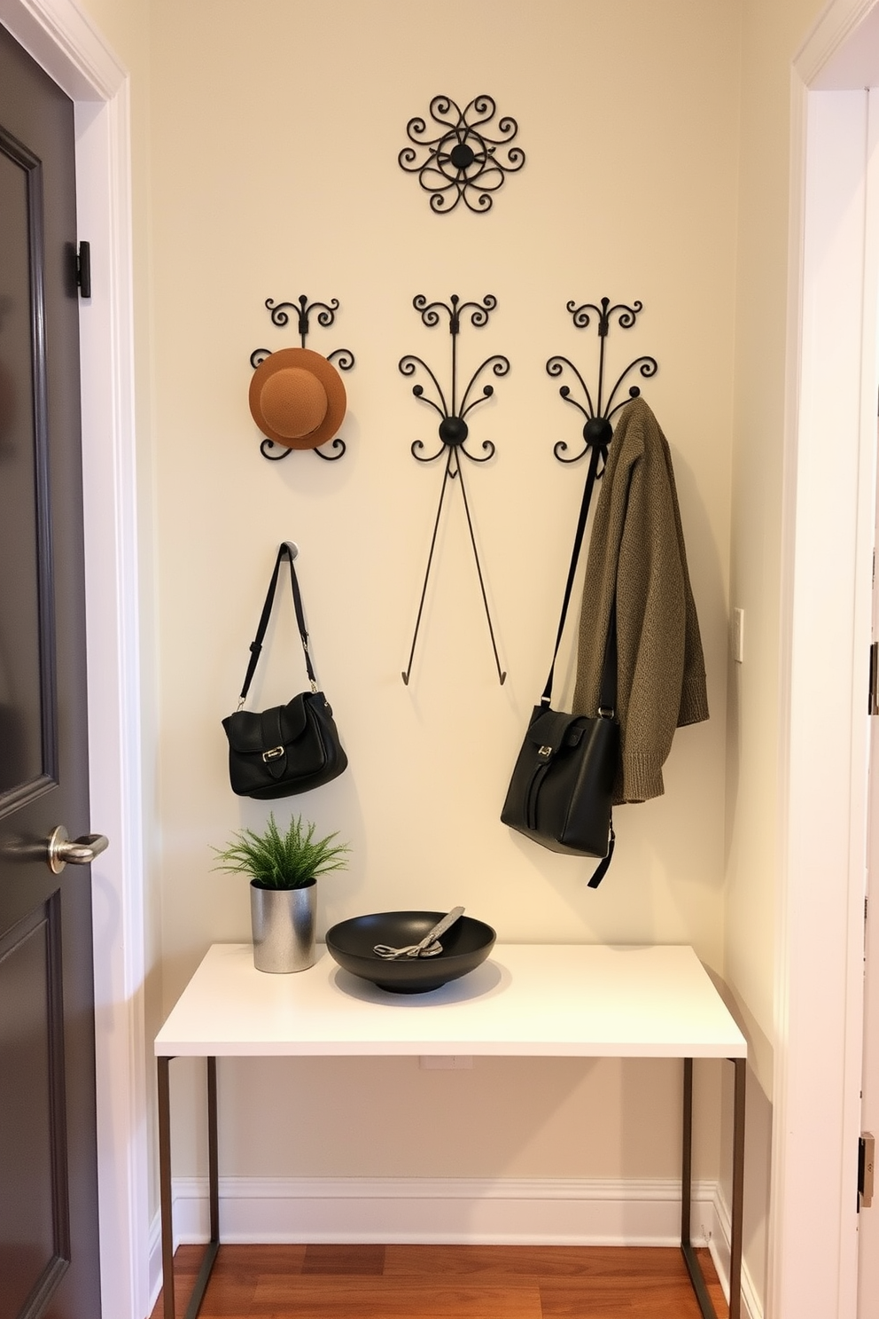 A narrow entryway features a stylish arrangement of decorative hooks for hats and bags mounted on a wall with a soft pastel color. Below the hooks, a sleek console table with a minimalist design holds a small potted plant and a decorative bowl for keys.