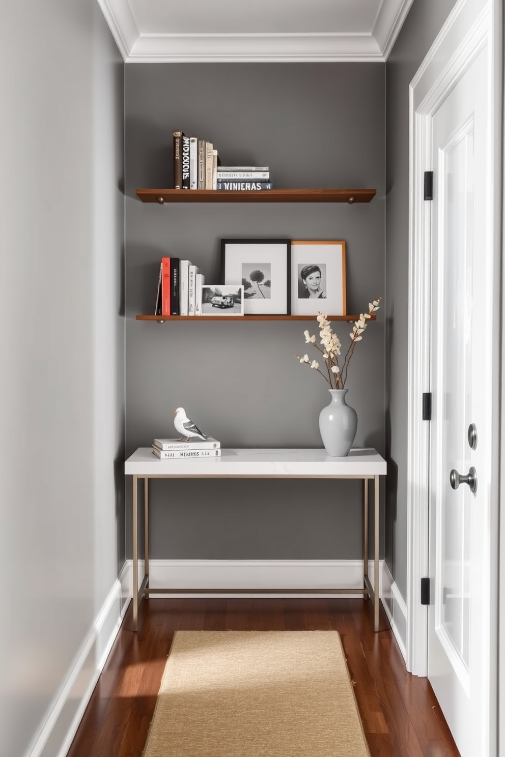 A narrow entryway features a sleek console table against the wall with a small bookshelf above it, showcasing decorative books and a few framed photos. The walls are painted in a soft gray, and a stylish runner rug adds warmth and texture to the space.