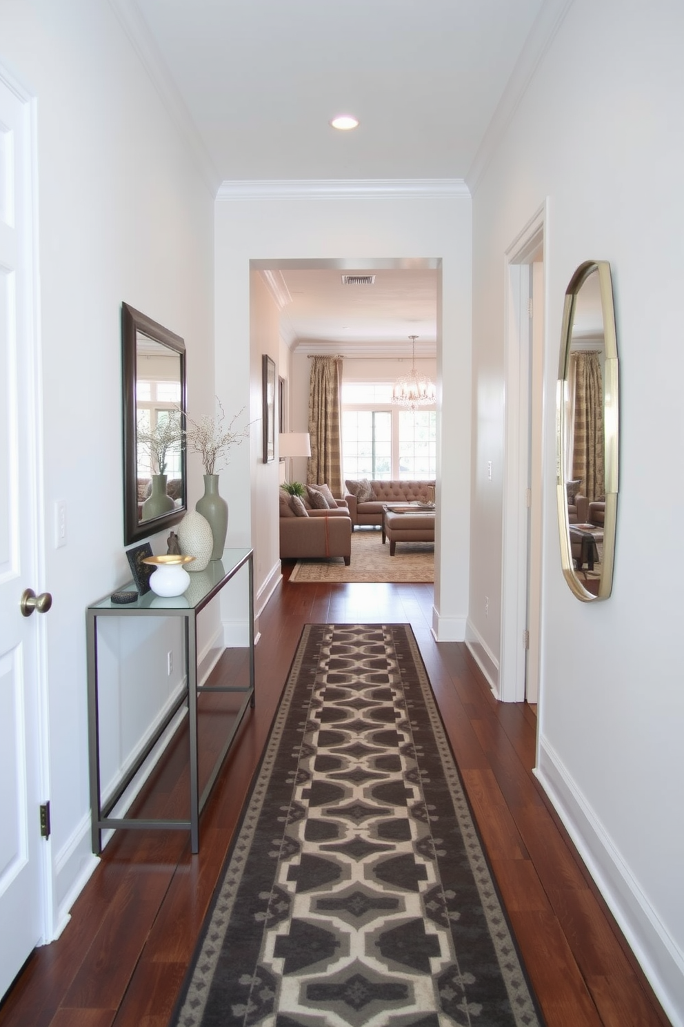 A narrow foyer features a stylish runner rug that stretches from the entrance to the living area, creating a sense of elongation and flow. The walls are adorned with light-colored paint, complemented by a small console table on one side, topped with decorative items and a mirror to enhance the space.