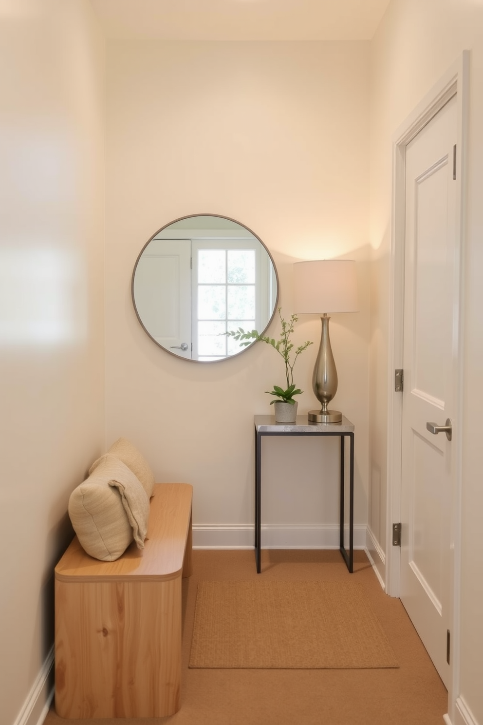 A narrow foyer designed with light colors creates an inviting and airy atmosphere. The walls are painted in a soft cream shade, complemented by a light wood bench and a slim console table. A large round mirror hangs above the console, reflecting natural light from a nearby window. Decorative elements such as a small potted plant and a stylish lamp add warmth and personality to the space.