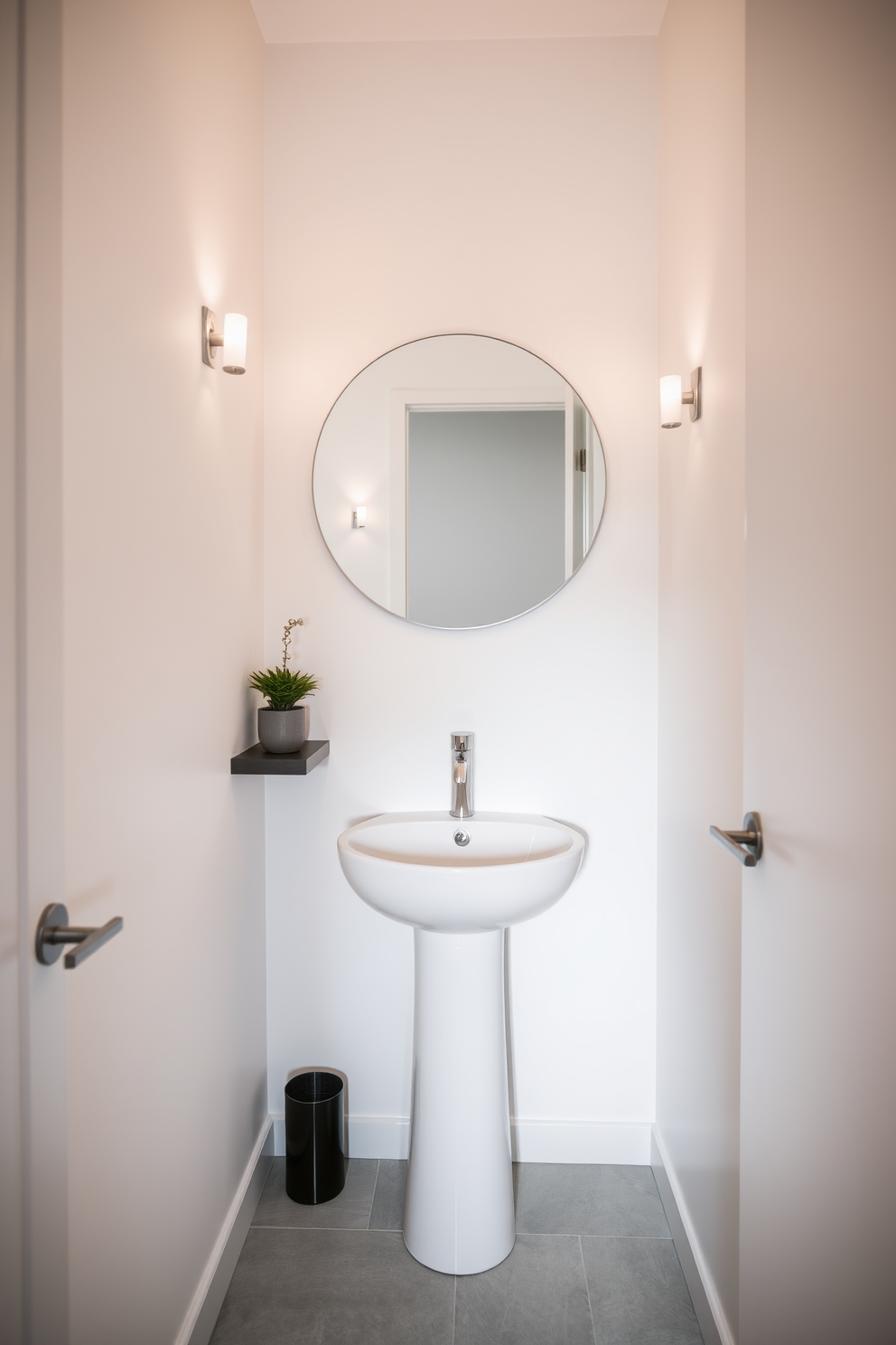 A narrow powder room features a sleek pedestal sink that enhances the minimalist aesthetic. The walls are painted in a soft white hue, creating an airy and open feel. A large round mirror hangs above the sink, reflecting light and adding depth to the space. Simple wall sconces provide warm illumination, creating a welcoming ambiance. The floor is adorned with light gray tiles that complement the overall design. A small potted plant sits on a floating shelf, adding a touch of greenery without overwhelming the limited space.