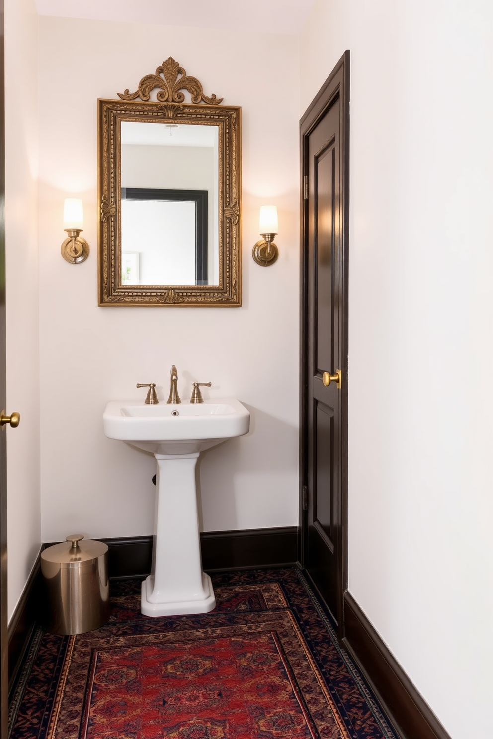 A cozy narrow powder room featuring a patterned rug that adds warmth and texture to the space. The walls are painted in a soft neutral tone, and a sleek pedestal sink is positioned against one side, complemented by elegant wall sconces for soft lighting. A stylish mirror with a decorative frame hangs above the sink, reflecting the charming details of the room. The patterned rug in rich colors ties the design together, creating an inviting atmosphere.