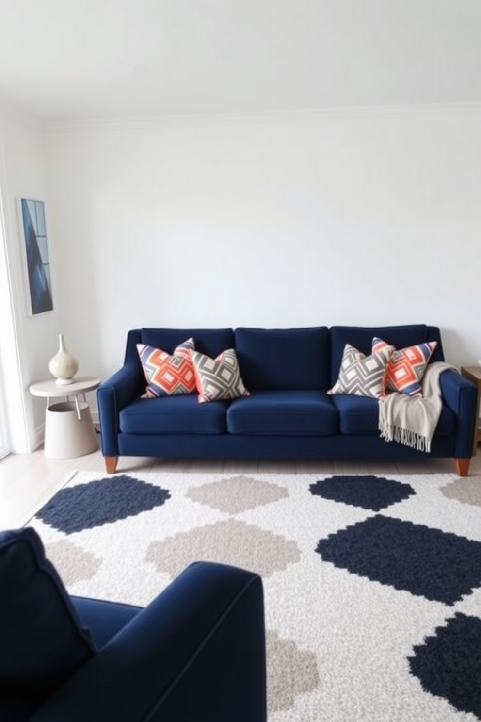 A modern living room featuring a navy blue couch adorned with bold geometric patterned throw pillows. The walls are painted in a soft white hue, and a large area rug with contrasting geometric designs anchors the space.