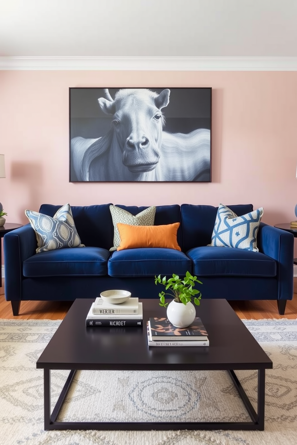 A stylish living room featuring a navy blue couch as the focal point. The walls are painted in a soft blush pink, creating a warm and inviting atmosphere. Accent pillows in various patterns complement the navy blue couch. A sleek coffee table sits in front, adorned with decorative books and a small plant for added charm.