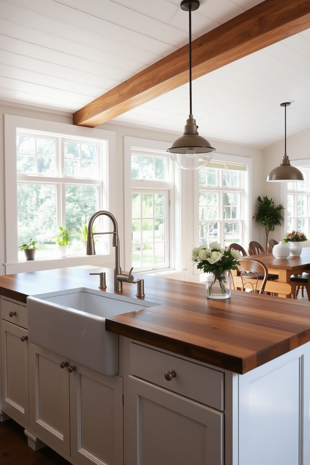 A charming open kitchen design featuring a large farmhouse sink with a brushed nickel faucet as the focal point. The cabinetry is painted in soft white, complemented by a rustic wooden island topped with a butcher block surface for added warmth. Natural light floods the space through large windows, illuminating the open layout that connects to the dining area. Decorative elements include potted herbs on the windowsill and stylish pendant lights hanging above the island to enhance the inviting atmosphere.