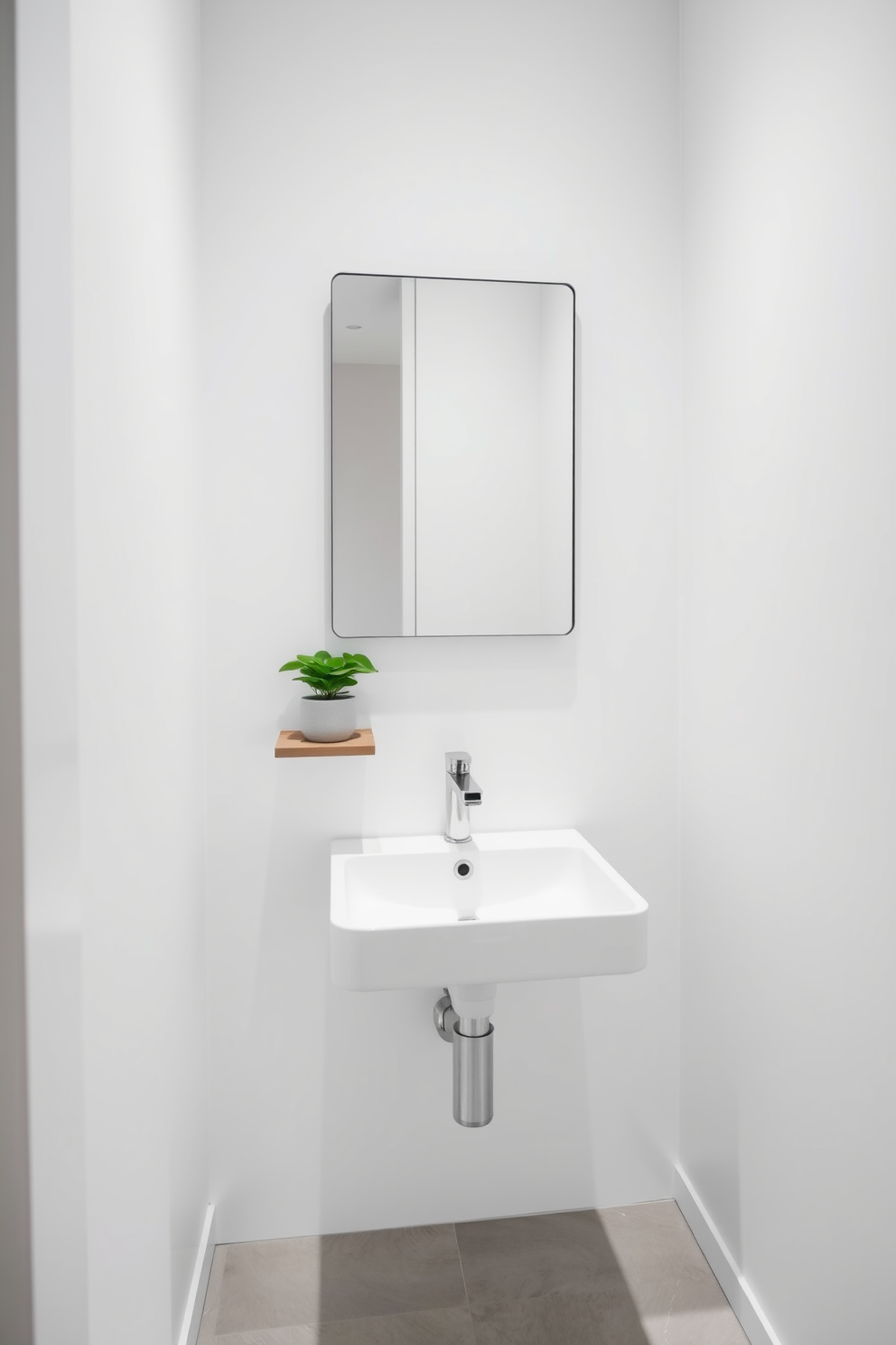 A minimalist powder room features a sleek wall-mounted sink with a simple rectangular mirror above it. The walls are painted in a crisp white, and the floor is adorned with light gray tiles, creating a serene atmosphere. A single potted plant sits on a floating shelf, adding a touch of greenery without cluttering the space. The overall design emphasizes clean lines and a clutter-free environment, perfect for a modern aesthetic.