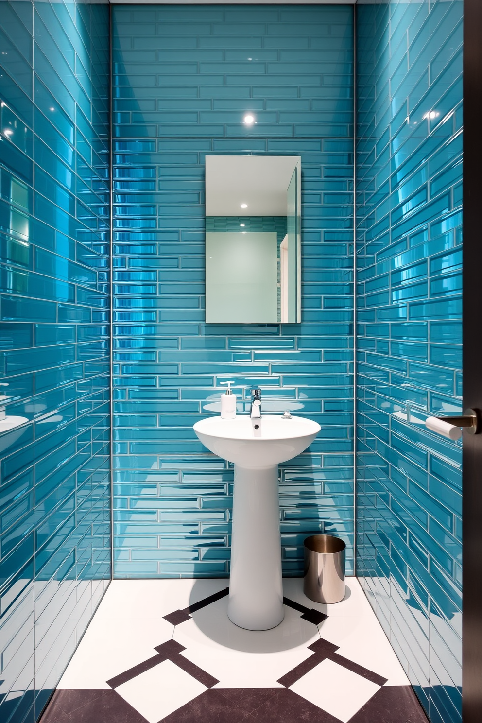 A stylish powder room featuring glass tiles that create a stunning reflective surface. The walls are adorned with sleek glass tiles in varying shades of blue and green, enhancing the sense of space and light. The floor is designed with a geometric pattern using contrasting tiles in white and charcoal. A modern pedestal sink sits against the wall, complemented by a chic wall-mounted faucet and a minimalist mirror above.