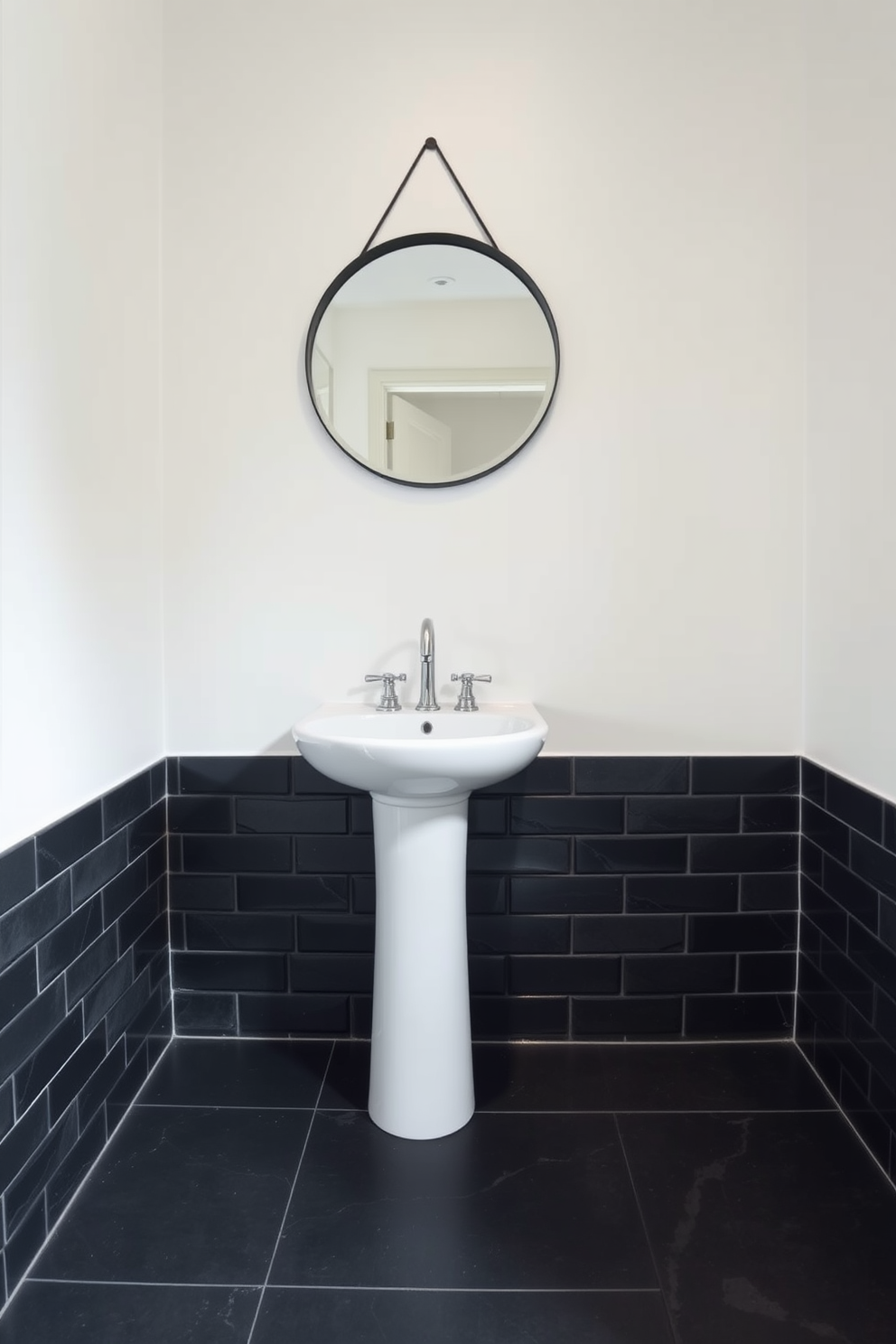 A striking powder room featuring black slate tiles that create a dramatic and sophisticated atmosphere. The walls are painted in a soft white to contrast the dark flooring, enhancing the overall elegance of the space. A sleek pedestal sink is positioned against the wall, complemented by a modern chrome faucet. Above the sink, a round mirror with a thin black frame reflects the stylish design elements of the room.