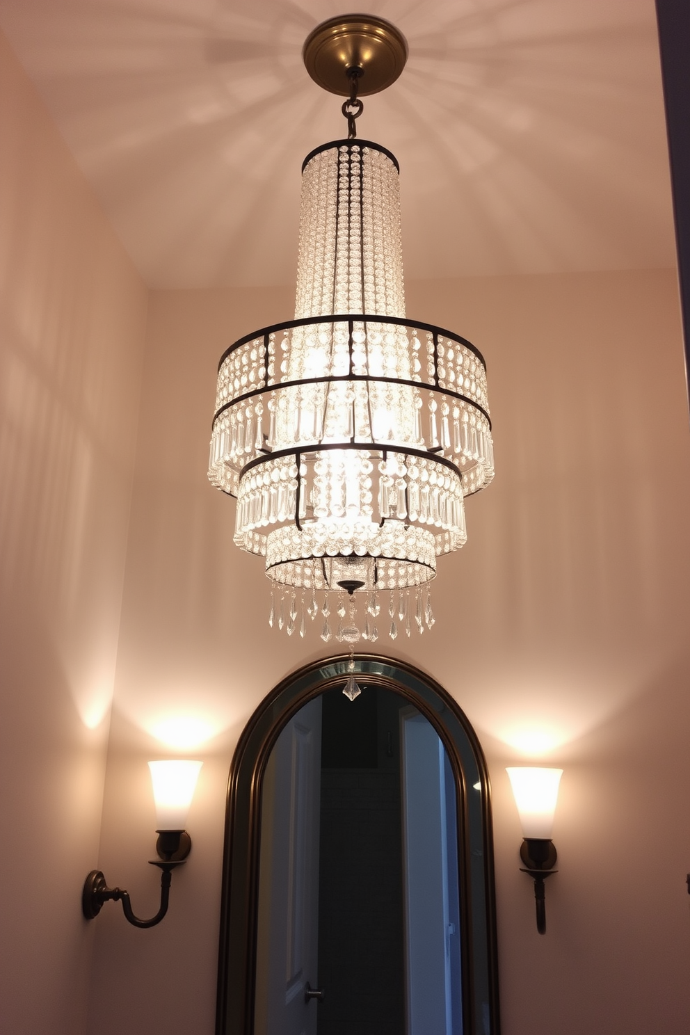 A luxurious powder room featuring a stunning multi-tiered chandelier that cascades from the ceiling, creating an elegant focal point. The chandelier is adorned with crystal accents that reflect light beautifully, enhancing the overall ambiance of the space. The walls are painted in a soft, neutral tone, providing a sophisticated backdrop for the intricate lighting design. Stylish sconces flank the mirror, offering additional illumination while complementing the grandeur of the chandelier.