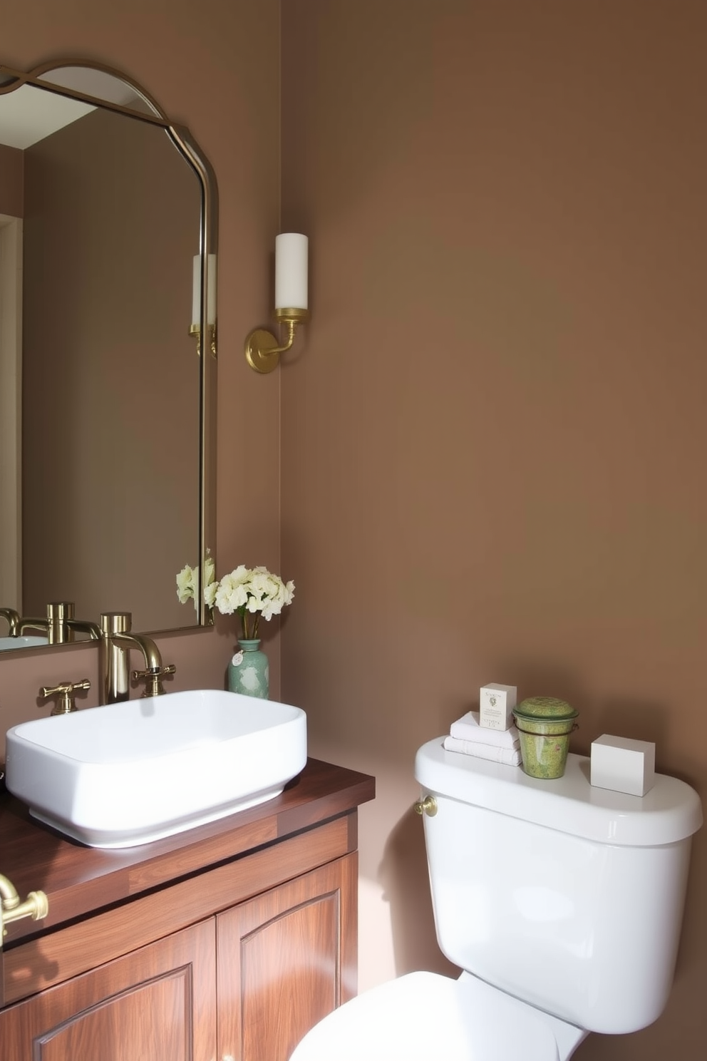 A warm taupe backdrop creates a cozy and inviting atmosphere in the powder room. The walls are painted in a soft taupe shade, complementing elegant fixtures and accessories. The vanity features a sleek white sink atop a rich wooden base, adding warmth to the space. Accents of gold in the faucet and mirror frame enhance the luxurious feel of the room.