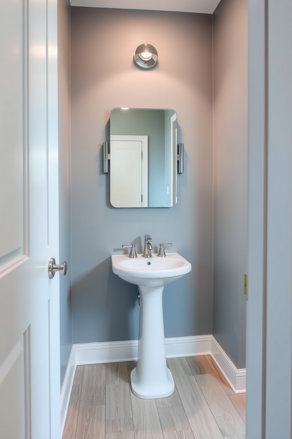 A tranquil powder room featuring cool gray-blue walls that create a serene atmosphere. The space includes a stylish pedestal sink and a sleek, modern mirror that enhances the calming vibe. The flooring is a light wood that complements the soft color palette, adding warmth to the room. Elegant fixtures in polished chrome complete the sophisticated look, making it a perfect retreat.