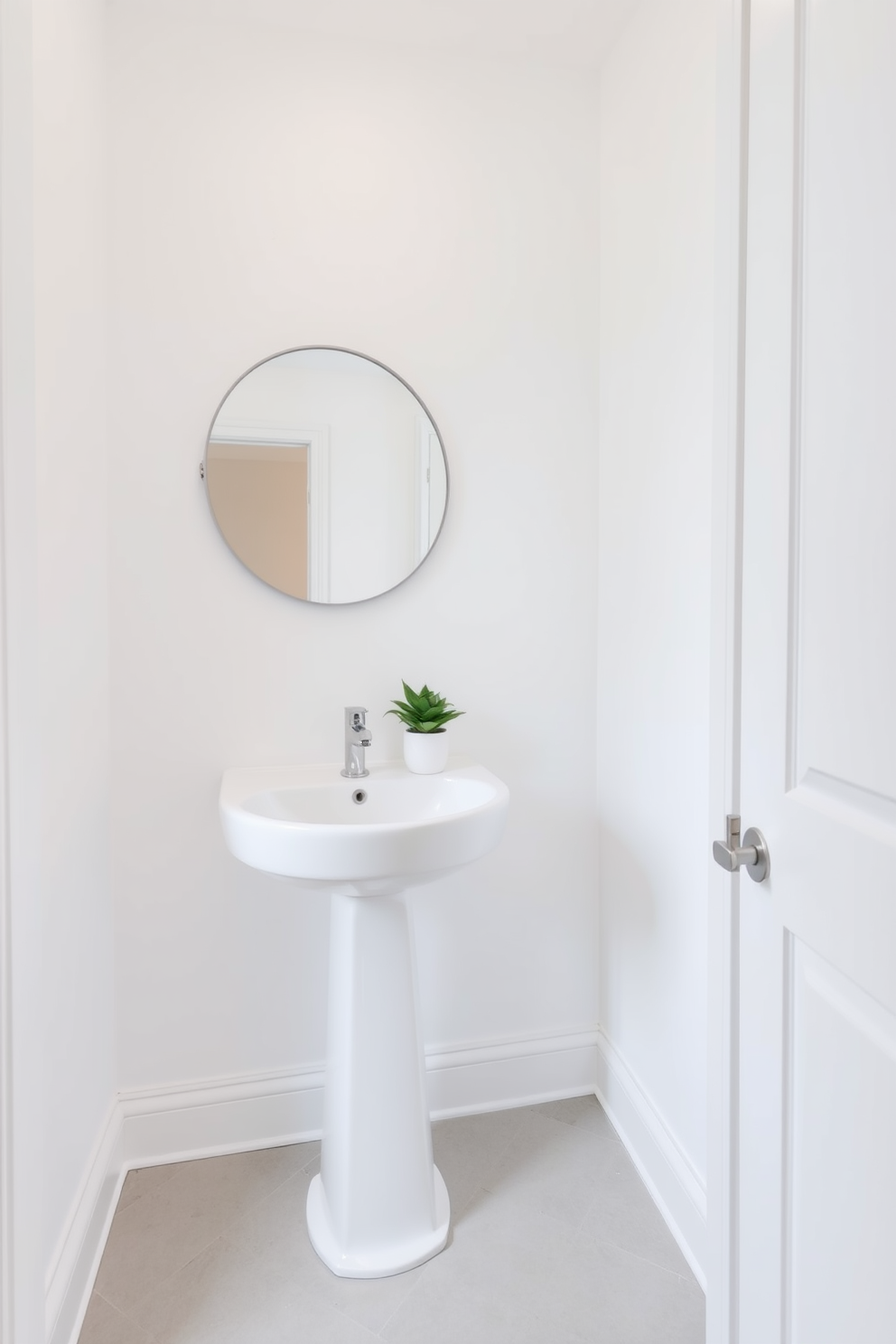 Bright white walls create a clean and airy atmosphere in the powder room. A sleek white pedestal sink complements the minimalist design, while a round mirror with a simple frame enhances the sense of space. The floor features light gray tiles that add subtle texture without overwhelming the room. A small potted plant on the sink adds a touch of greenery, creating a fresh and inviting ambiance.