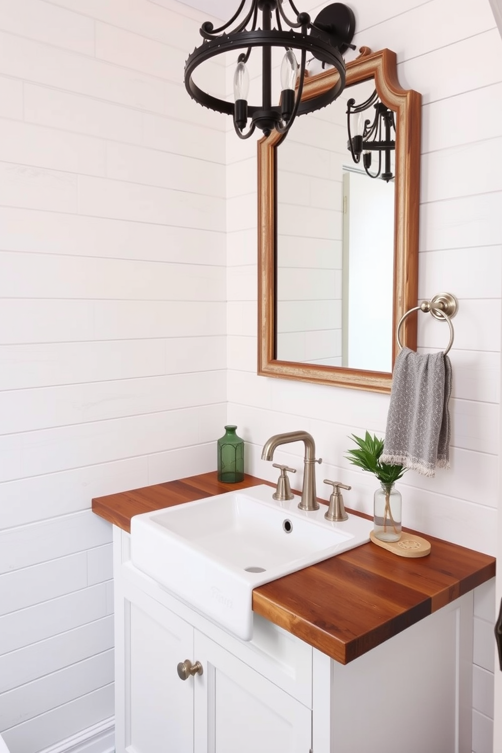 A vintage farmhouse sink with a modern twist serves as the centerpiece of the powder room. The sink is complemented by sleek, contemporary fixtures and surrounded by shiplap walls in a soft white hue. The countertop features a rich wooden finish, adding warmth to the space. A stylish mirror with an antique frame hangs above, reflecting the elegant lighting from a rustic chandelier.