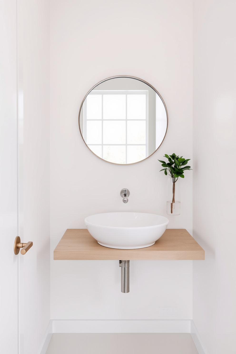 A floating sink with a minimalistic appeal is the focal point of this powder room. The sleek design features clean lines and a wall-mounted faucet that enhances the open space. The walls are painted in a soft white to create a bright and airy atmosphere. A large round mirror above the sink reflects natural light, while a small potted plant adds a touch of greenery.