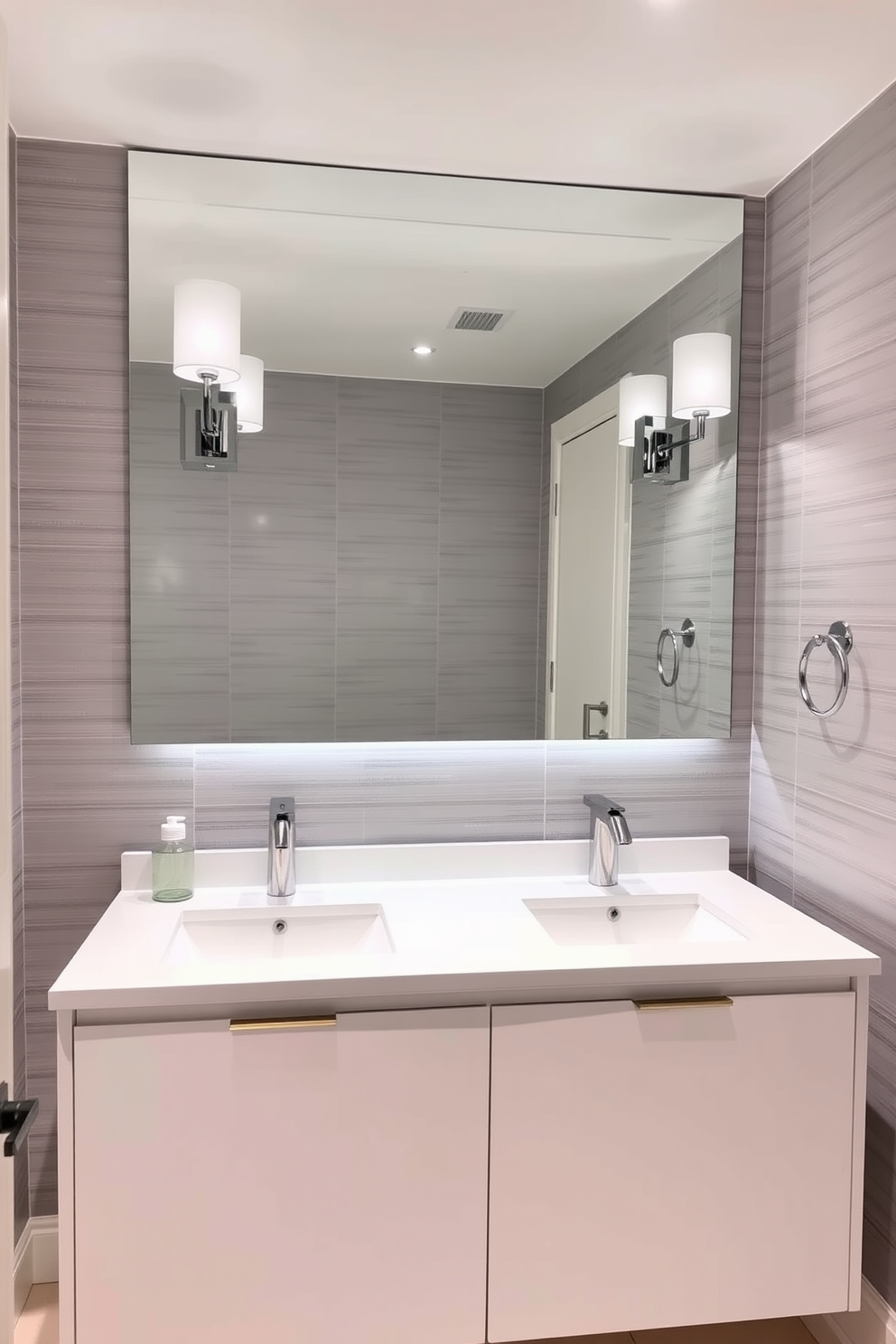 A contemporary powder room featuring a sleek double sink vanity with a clean white finish. The countertop is made of polished quartz, providing a spacious feel and a touch of luxury. Above the vanity, a large frameless mirror reflects the elegant lighting fixtures on either side. The walls are adorned with a subtle textured wallpaper in soft gray tones, enhancing the modern aesthetic.