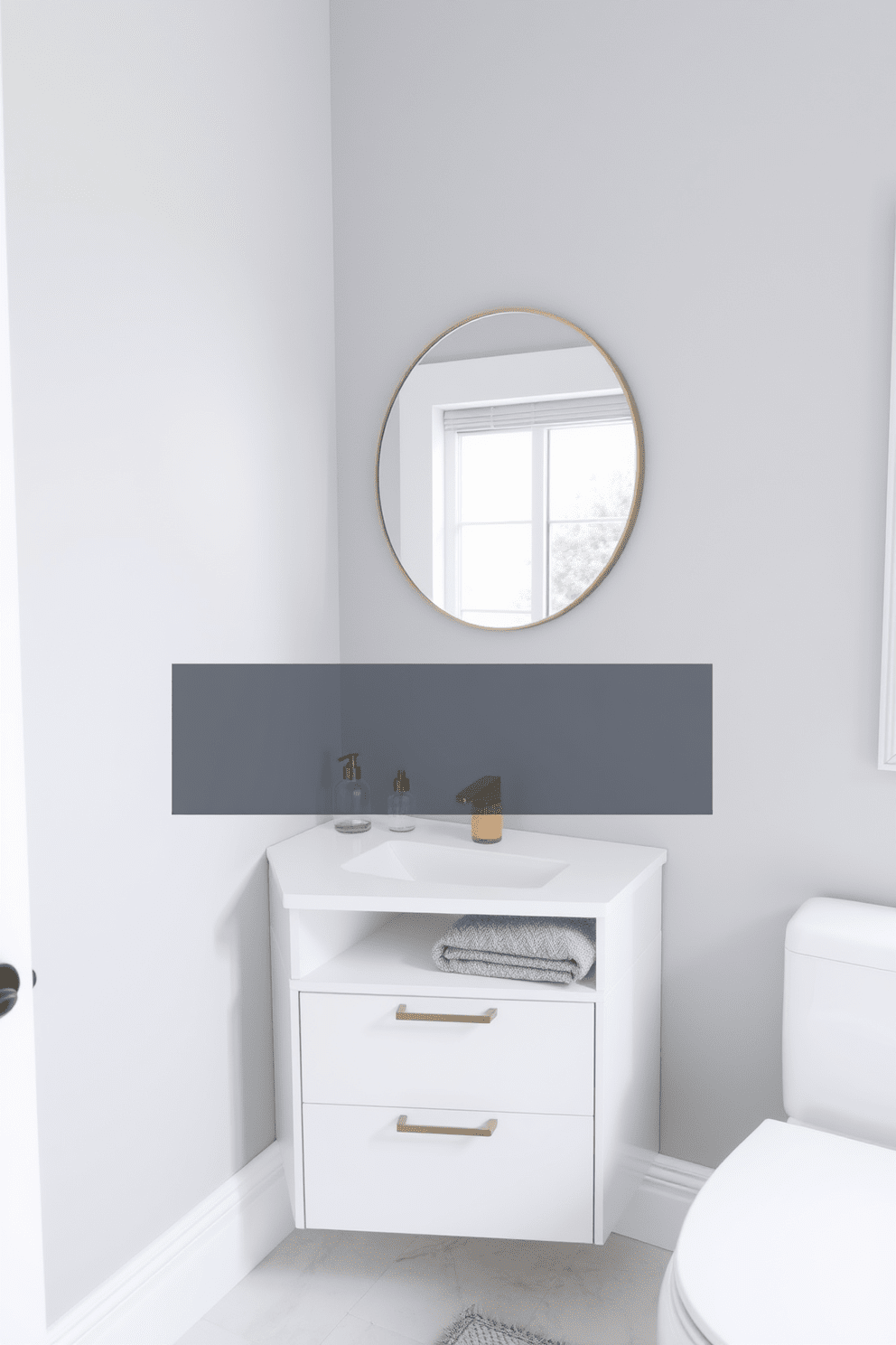 A stylish corner vanity installation designed for a small bathroom. The vanity features a sleek design with a white countertop and a single undermount sink, maximizing space while maintaining elegance. The walls are painted in a soft gray hue, enhancing the room's brightness. A round mirror with a minimalist frame hangs above the vanity, reflecting the natural light from a nearby window.