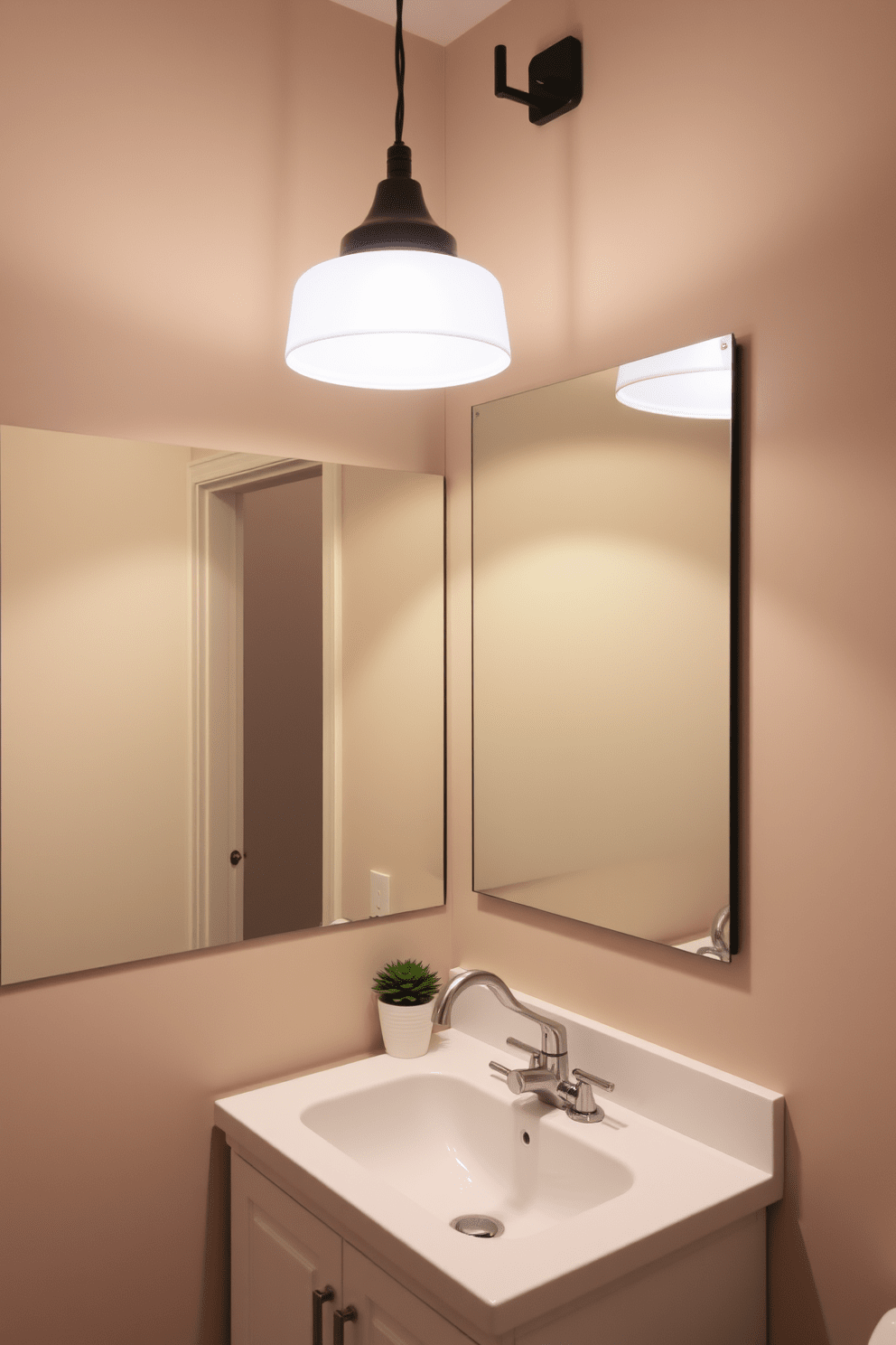 A cozy quarter bathroom featuring soft, ambient lighting that creates a warm atmosphere. The walls are painted in a light taupe color, and a stylish pendant light hangs above the sink area, casting a gentle glow. The sink is a sleek, modern design with a brushed nickel faucet, complemented by a small potted plant on the countertop. A large mirror with a minimalist frame reflects the light, making the space feel larger and more inviting.