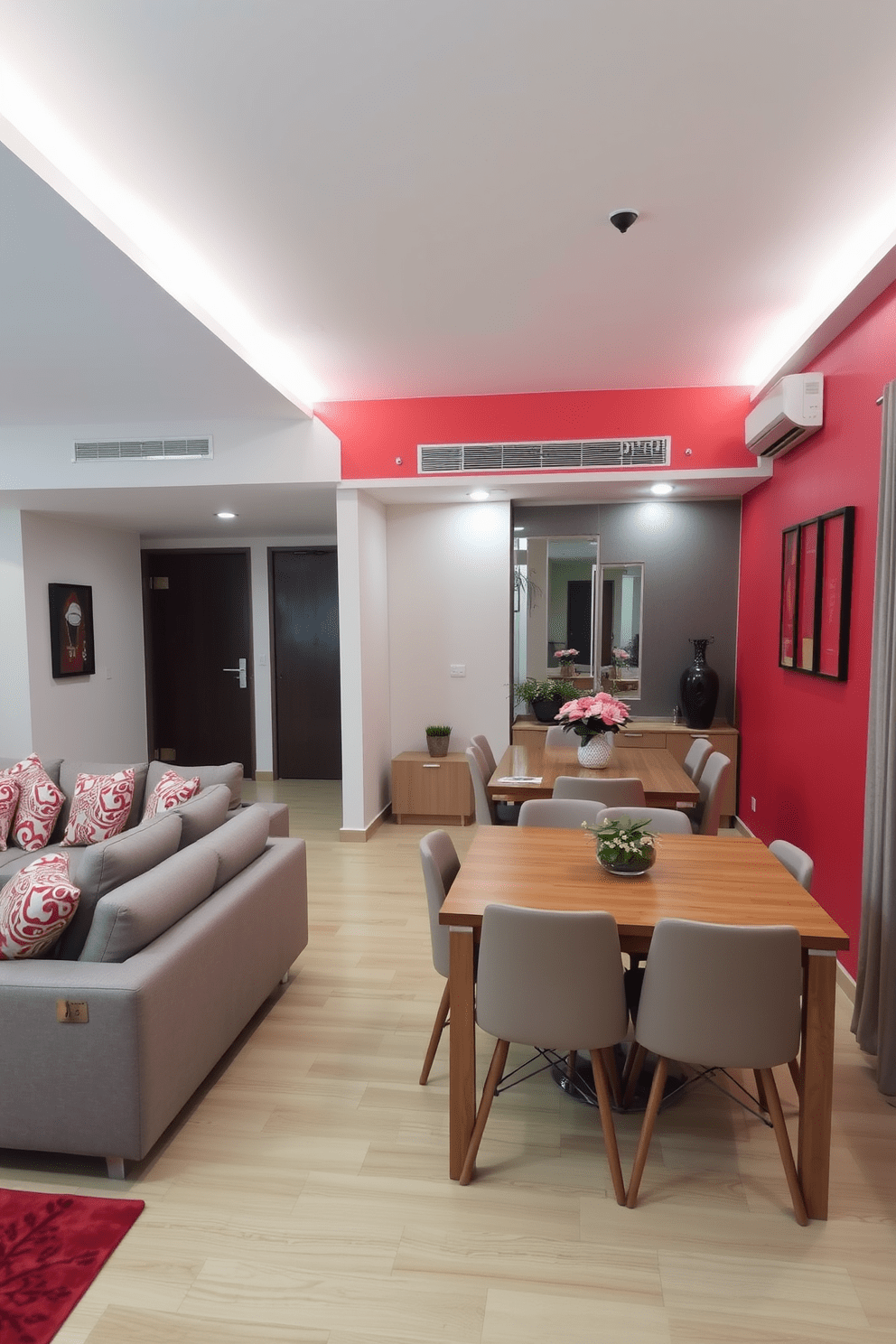 A stylish apartment interior featuring a bold red accent wall that complements neutral beige and gray furnishings. The living area includes a sleek gray sofa adorned with red and white patterned cushions, creating a cozy yet vibrant atmosphere. In the dining space, a wooden table set against the red wall is surrounded by neutral-toned chairs, enhancing the overall balance of the room. Decorative elements such as red artwork and potted plants add a touch of life and warmth to the space.