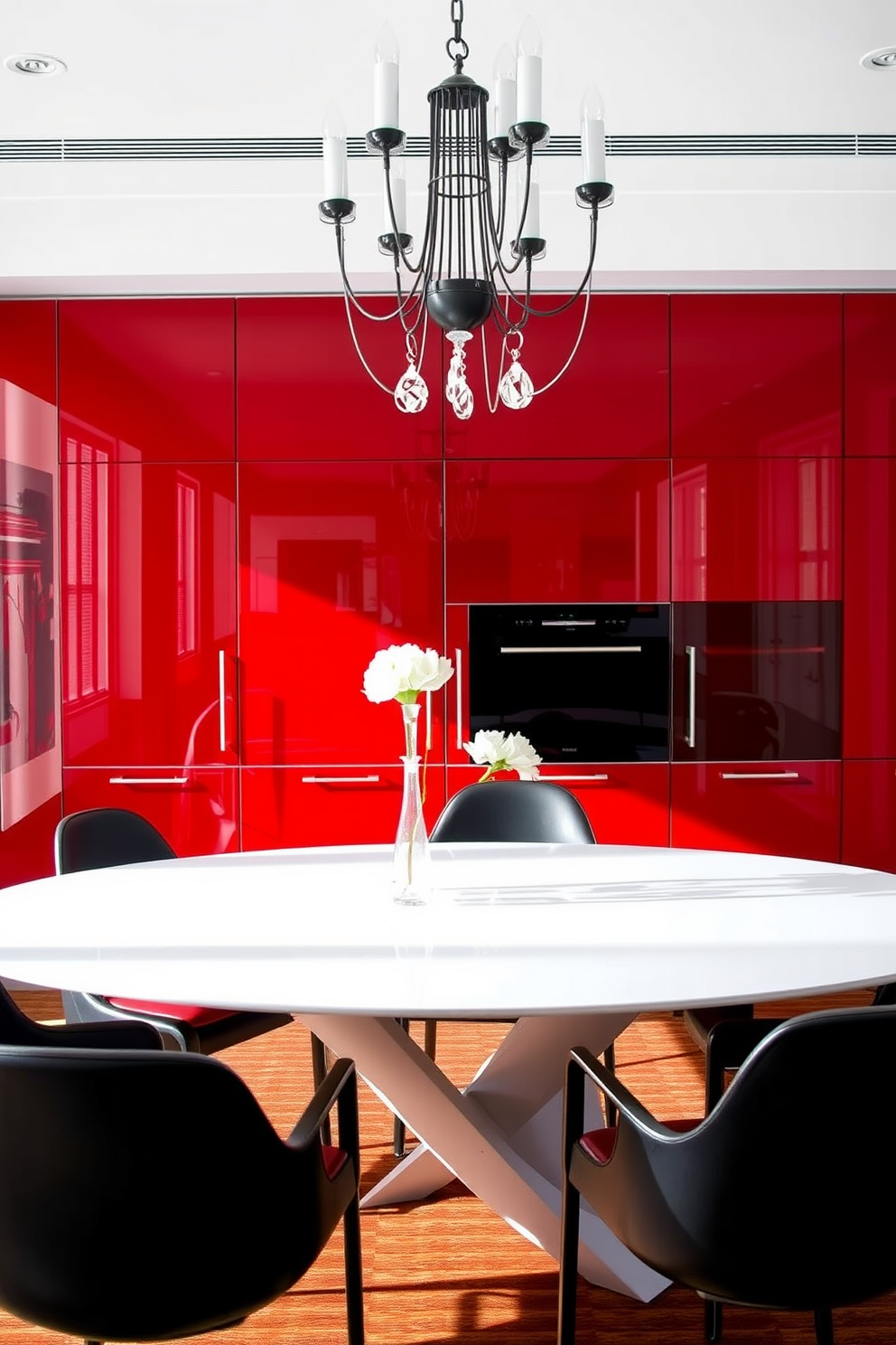 A contemporary dining room featuring glossy red cabinets that reflect light beautifully. The cabinets are paired with a sleek, white dining table surrounded by elegant black chairs. The walls are adorned with modern art pieces that complement the vibrant red tones. A stylish chandelier hangs above the table, adding a touch of sophistication to the space.