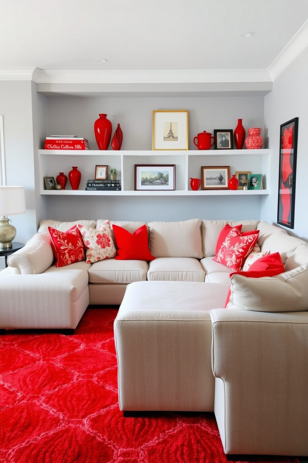 A bright family room featuring a cozy sectional sofa in neutral tones. The room is accented with vibrant red throw pillows and a striking red area rug that ties the space together. On the shelves, there are decorative items in various shades of red, including books, vases, and framed photos. The walls are painted a soft gray, providing a perfect backdrop for the bold accent pieces.