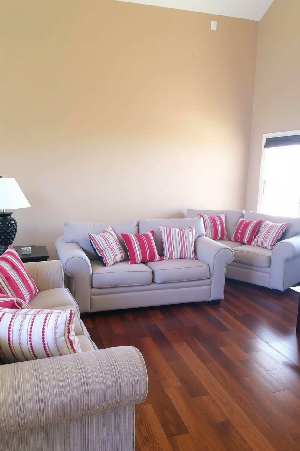 A cozy family room featuring sofas adorned with red and white striped cushions. The walls are painted in a warm beige tone, complementing the rich wooden flooring.