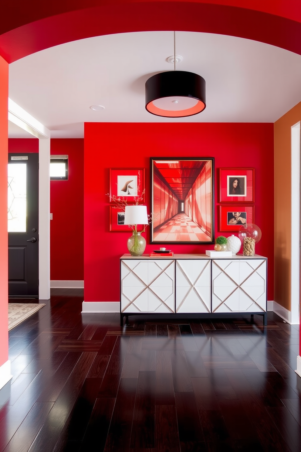 A vibrant foyer featuring a bold red accent wall that creates a striking backdrop for decor. The space is adorned with red framed artwork that enhances the ambiance and invites guests in with warmth and style. The flooring is a sleek dark hardwood that contrasts beautifully with the red tones. A modern console table with a geometric design sits against the wall, topped with decorative items that complement the artwork.