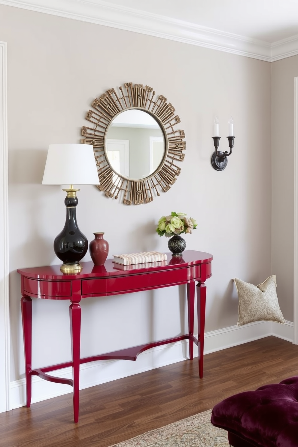 A striking crimson console table stands against the wall, topped with a decorative mirror that reflects the elegant surroundings. The foyer is adorned with soft lighting, highlighting the rich colors and textures of the space.