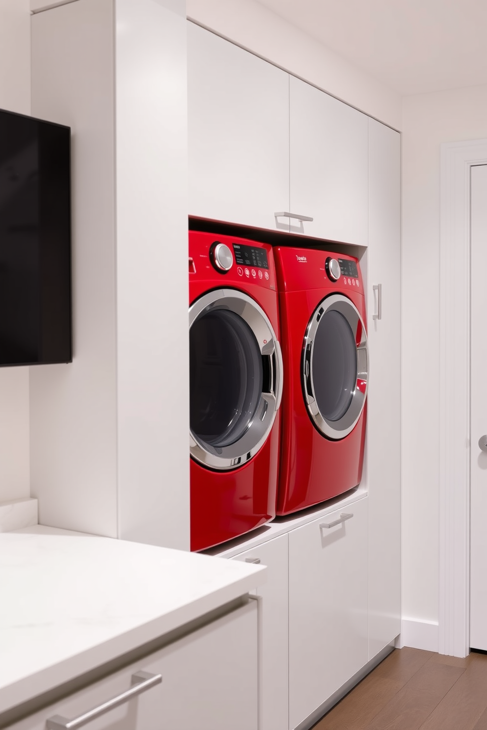 A contemporary laundry room features a bold red washer and dryer set seamlessly integrated into sleek cabinetry. The walls are painted a crisp white, creating a vibrant contrast with the red appliances, while a stylish countertop provides space for folding clothes.