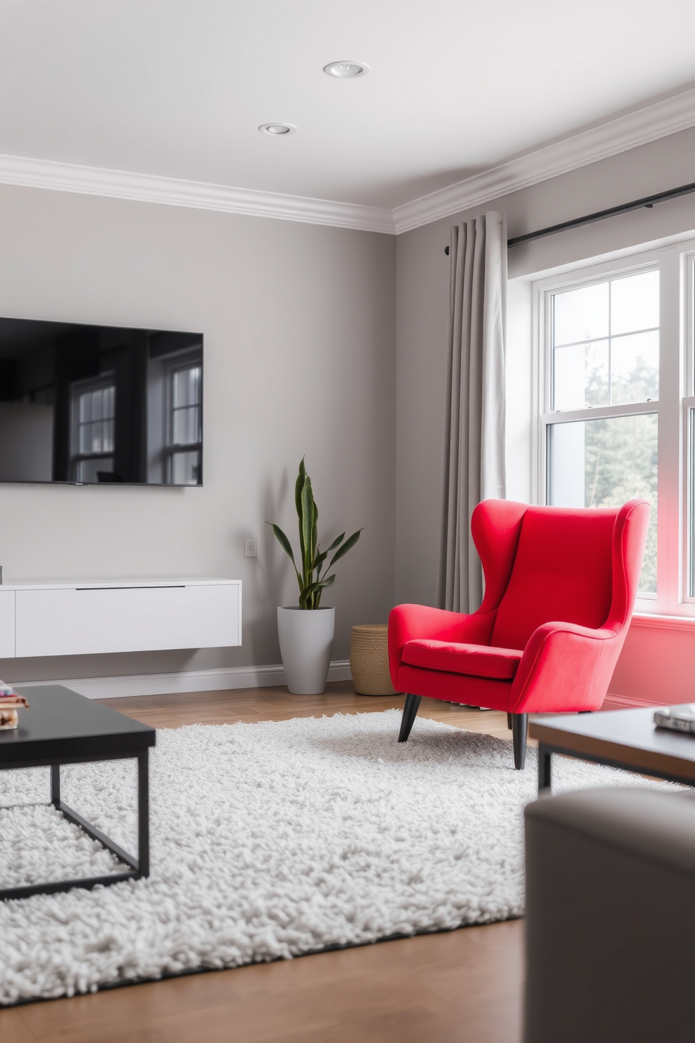 A bright red accent chair is positioned in the corner of a modern living room. The space features a neutral color palette with soft gray walls and a plush area rug, creating a striking contrast that highlights the chair.