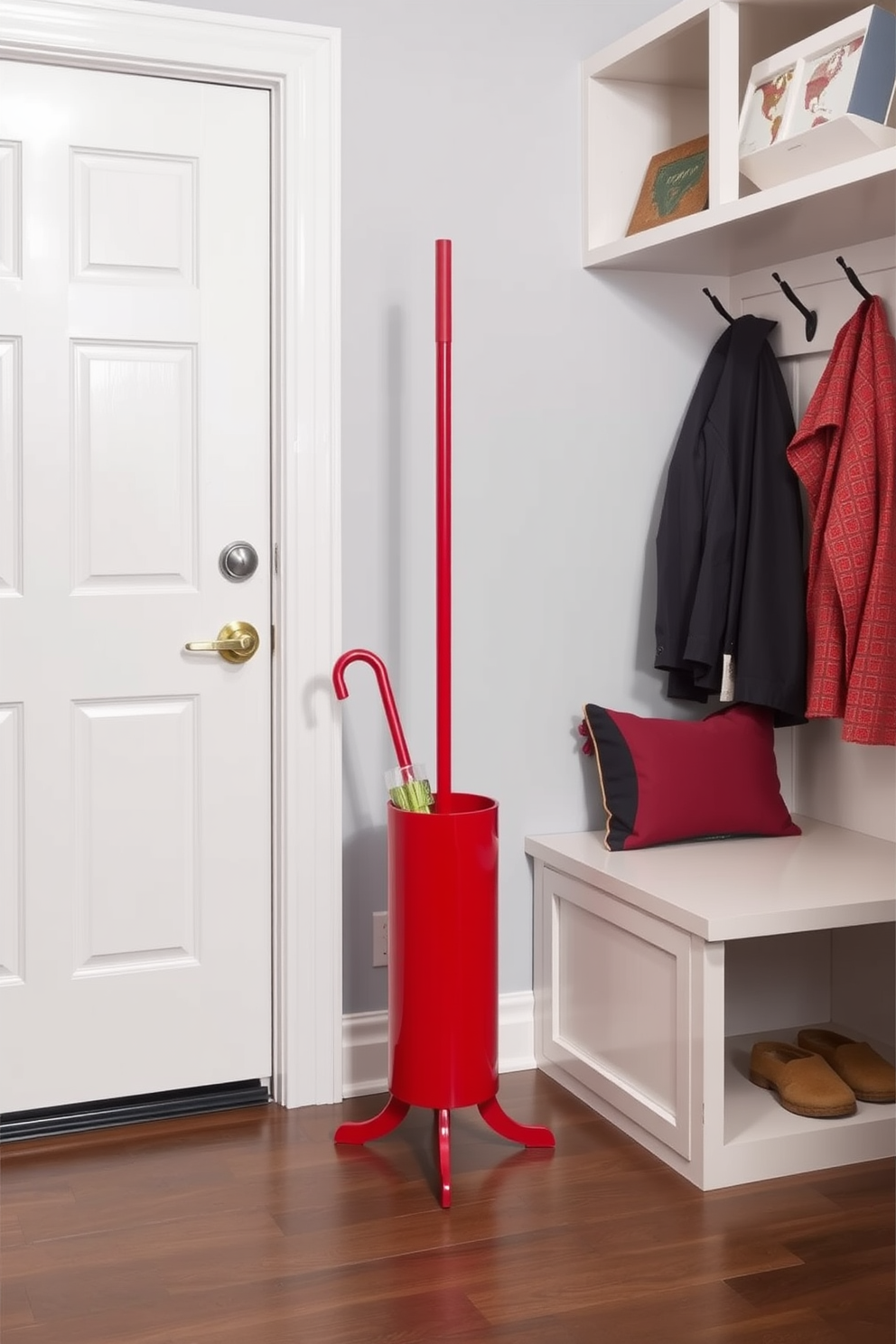 A stylish red umbrella stand is positioned by the door, adding a pop of color and functionality to the space. The stand is crafted from durable materials, featuring a sleek design that complements the overall decor. The mudroom is designed with a combination of practical storage solutions and aesthetic appeal. It includes built-in benches, hooks for coats, and a vibrant color palette that enhances the welcoming atmosphere.