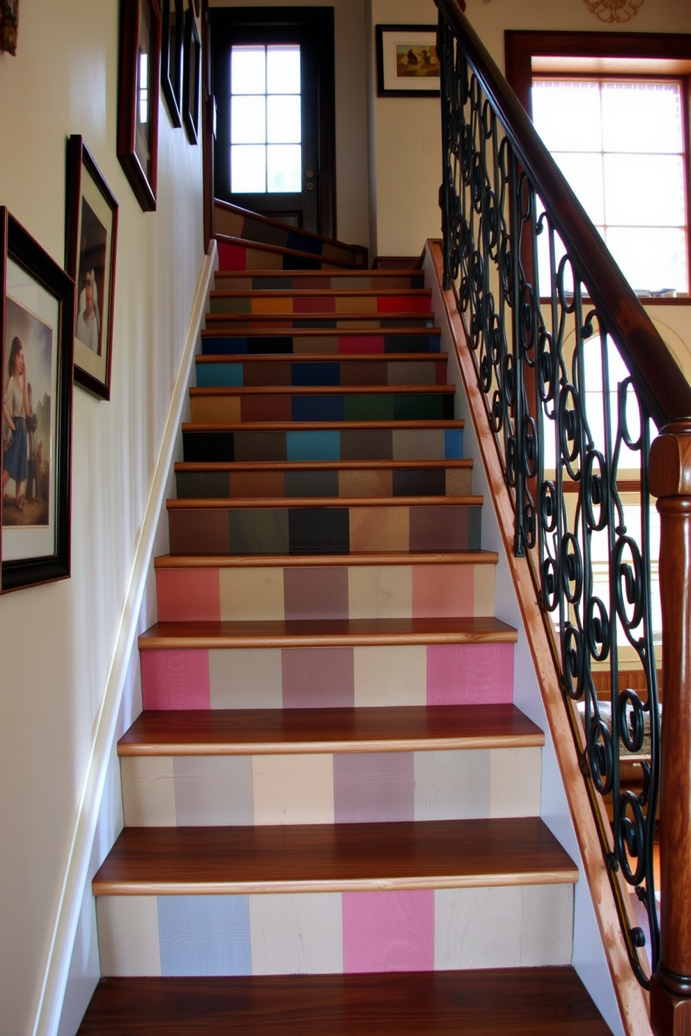 A rustic staircase features wooden steps with painted risers in a variety of vibrant colors. The staircase is adorned with a wrought iron railing that adds a touch of elegance to the rustic charm. Natural light filters through a nearby window, illuminating the wood grain and colors of the risers. Surrounding the staircase, the walls are decorated with framed artwork that complements the rustic aesthetic.